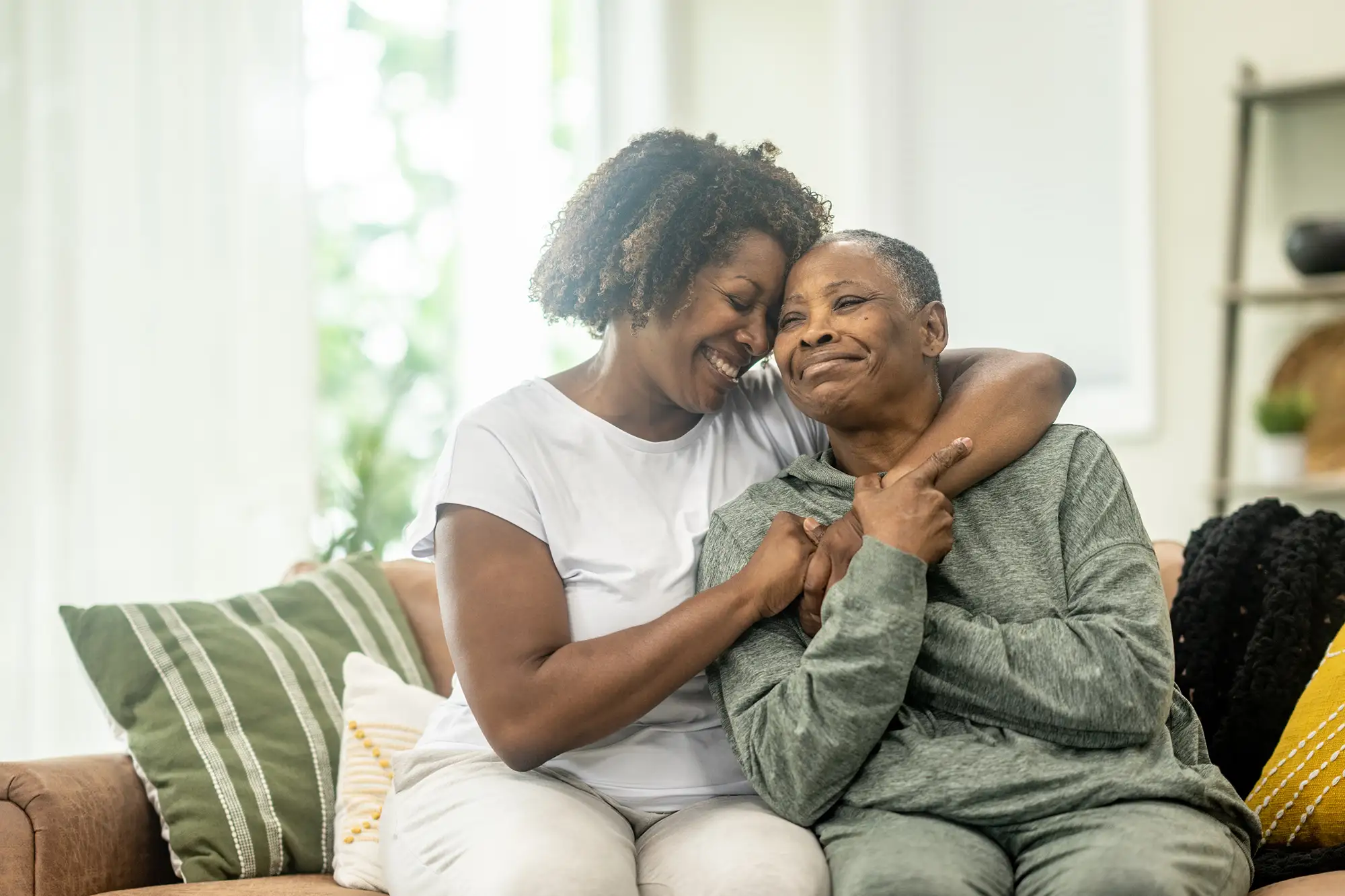 iStock-1533631809-June-Blog-Featured-Image Adult daughter hugging her senior mother, who is experiencing cognitive decline. They are talking about Alzheimer's Care at Charter Senior Living of Danvers in MA.